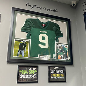 Doyen Grant proudly displays his Morrisville football jersey at his gym.