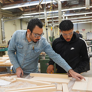 Professor Mohammadali Azadfar works with a student in a wood products lab.