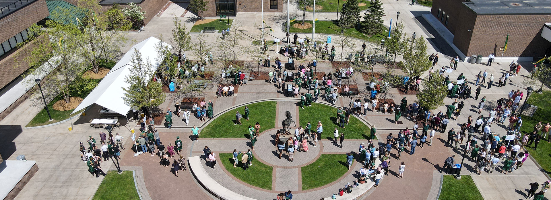 Graduates and loved ones gather in the Admin Quad during 2023 Commencement.