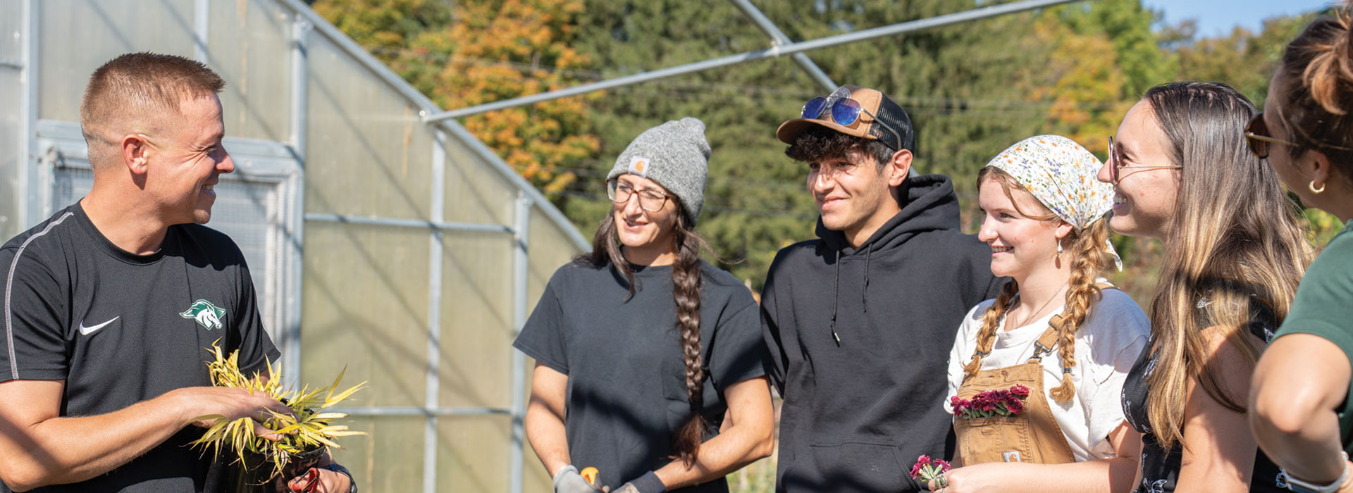 Adam Olinski works with horticulture students in the greenhouse.