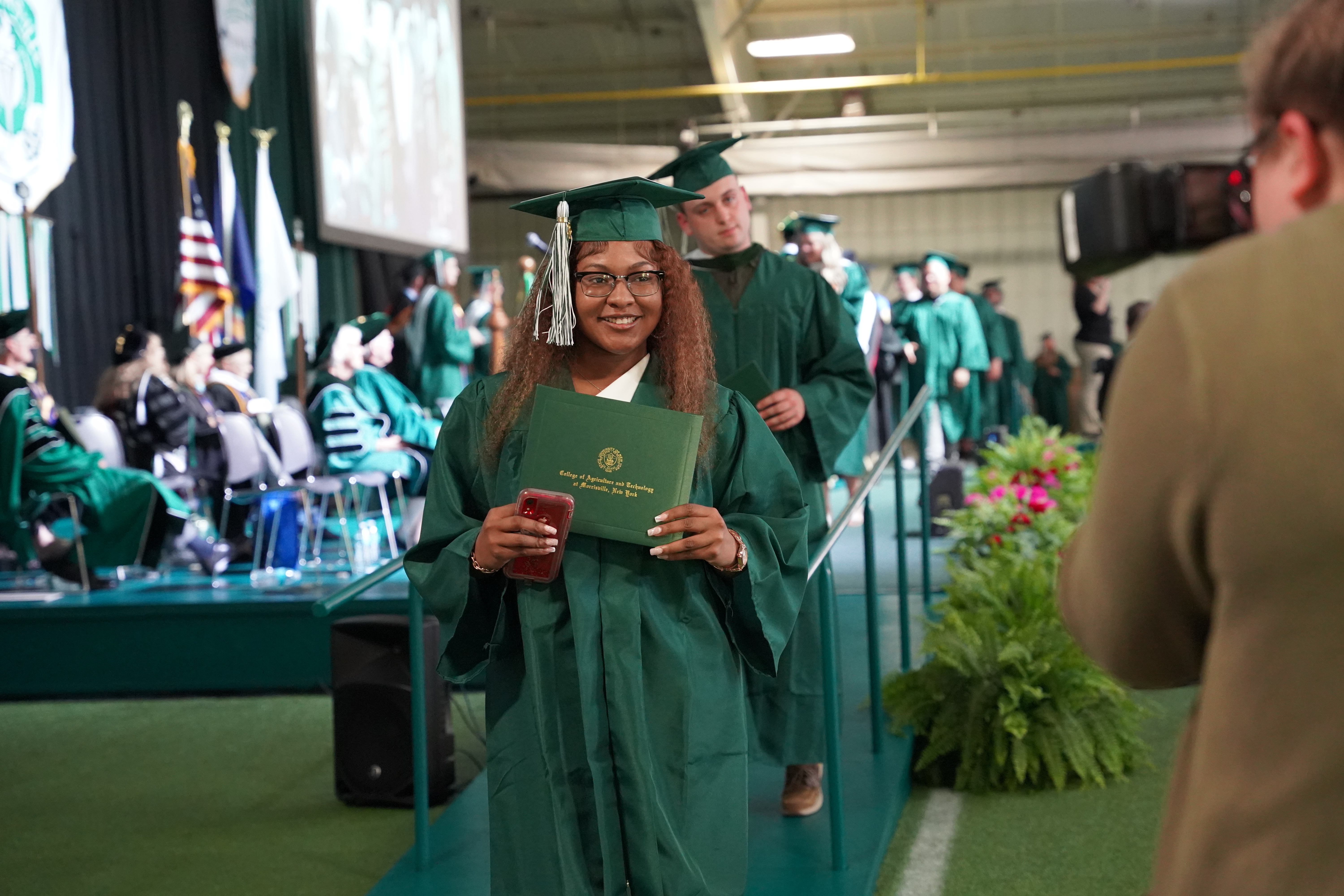 a graduate holds her diploma