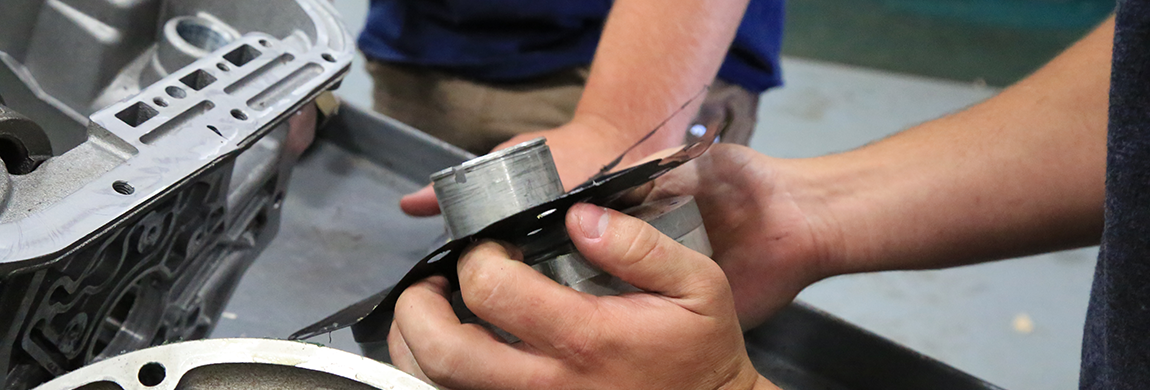 Close up of students working on engine