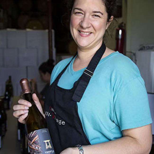 Nova Cadamatre holds a bottle of Trestle Thirty One wine