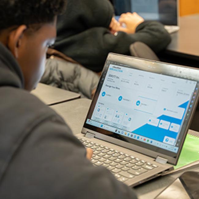 A student works on a laptop.