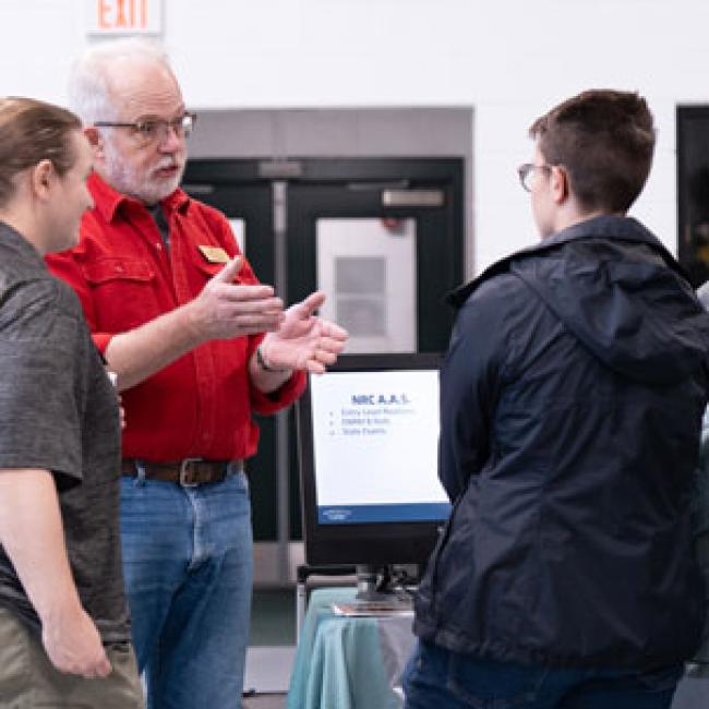 Professor speaking individually to a visitor