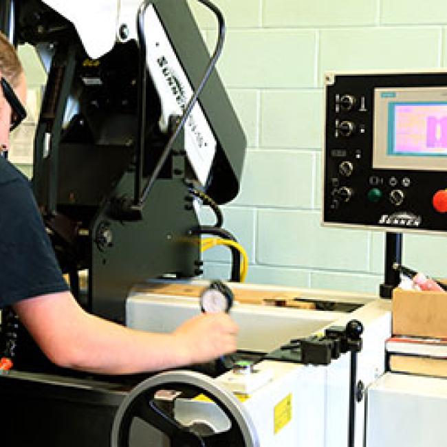 a student uses manufacturing equipment