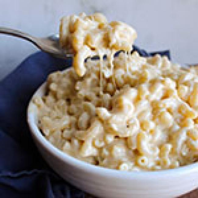 Spoon raising a scoop of creamy Mac n' Cheese