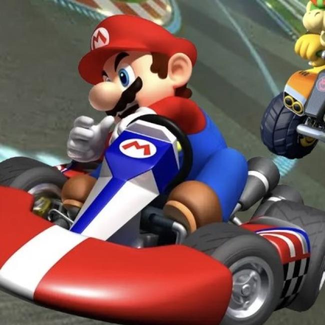 Mario in a red go-kart taking a hard turn on a track.