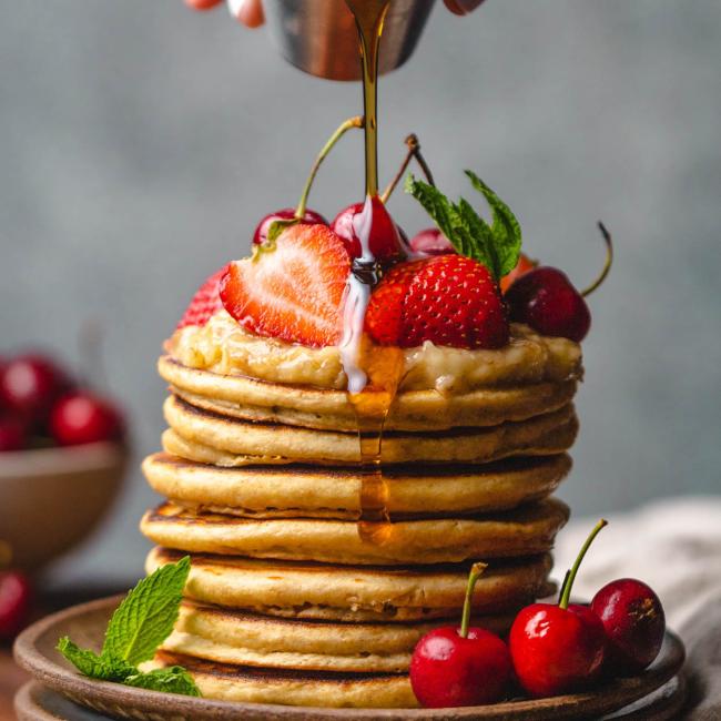 Stack of pancakes with strawberries and syrup