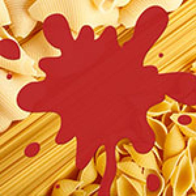 Multiple shapes of pasta with a red sauce splatter on top