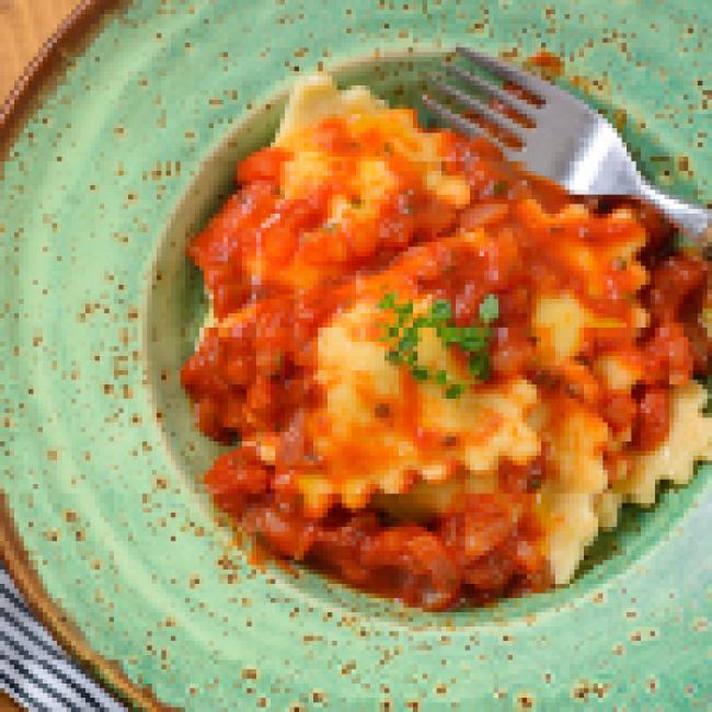 Ravioli in green dish with fork