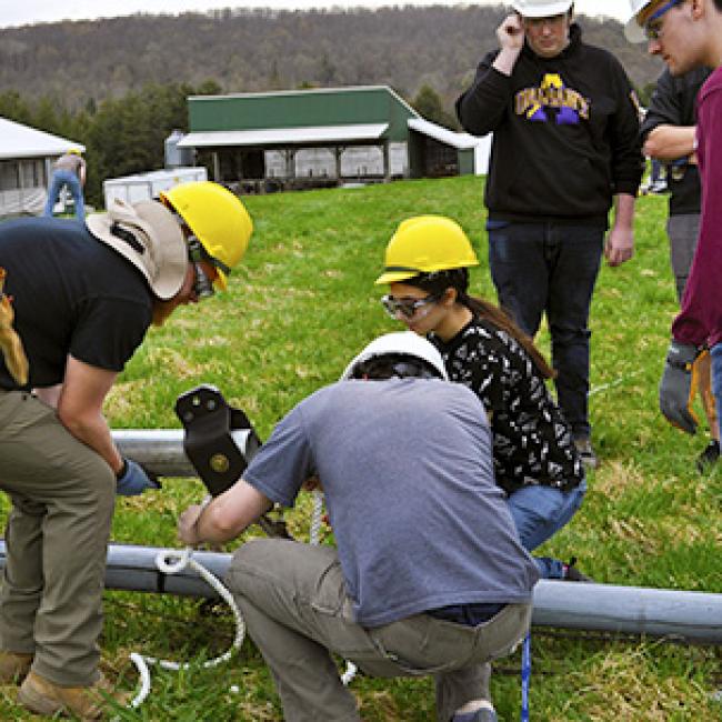 students work on repairing wind turbine