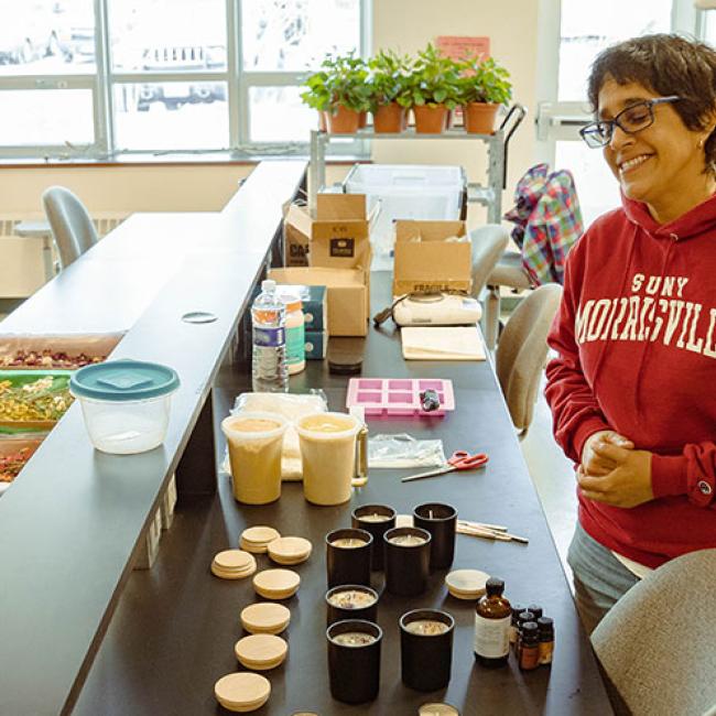 Students use pressed oils to create scented candles.