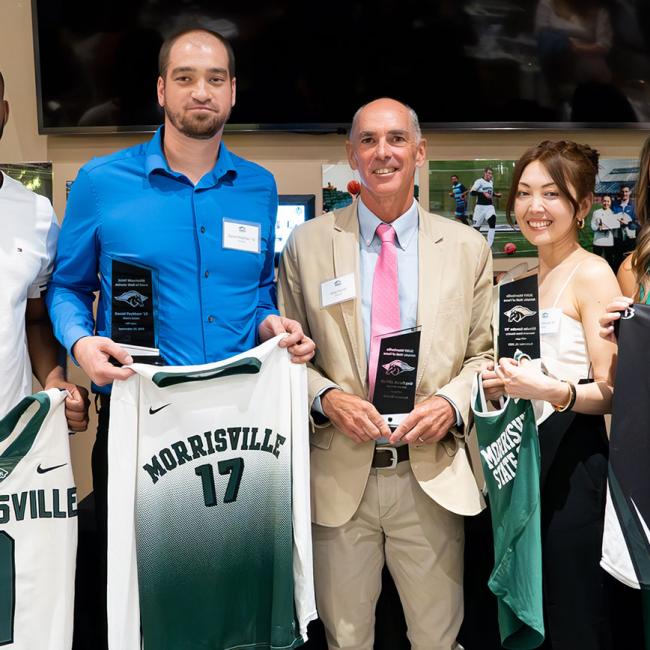 From left: Brandon Hanks '14, Lemar Johnson '14, Daniel Peckham '16, Greg Carroll, Athletics Director, 2001-19, Ritsuko Sonobe '00, Shelby (Wood) Rosaschi '15, Jordan Anderson '17