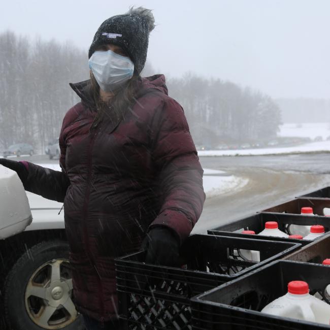 Professor Ashley Marshall distributes milk during a dairy drive-thru.