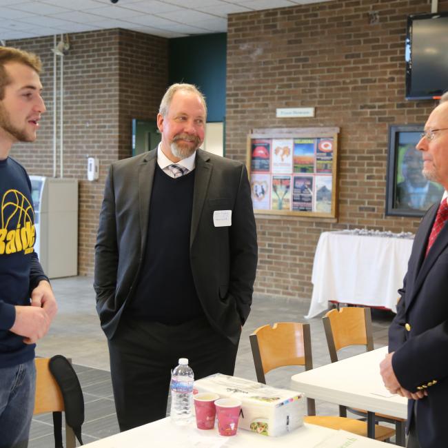 Richard Ball, commissioner of the New York State Department of Agriculture and Markets, speaks with Jacob Kline, an agricultural business student from Myerstown, Pennsylvania, and Christopher Nyberg, Dean of the School of Agriculture and Natural Resources.