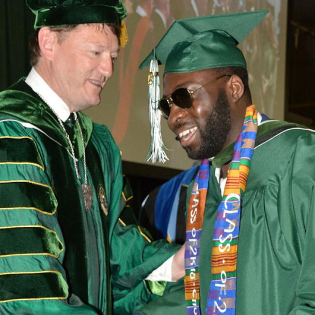 President Rogers congratulates Charles Okine at commencement
