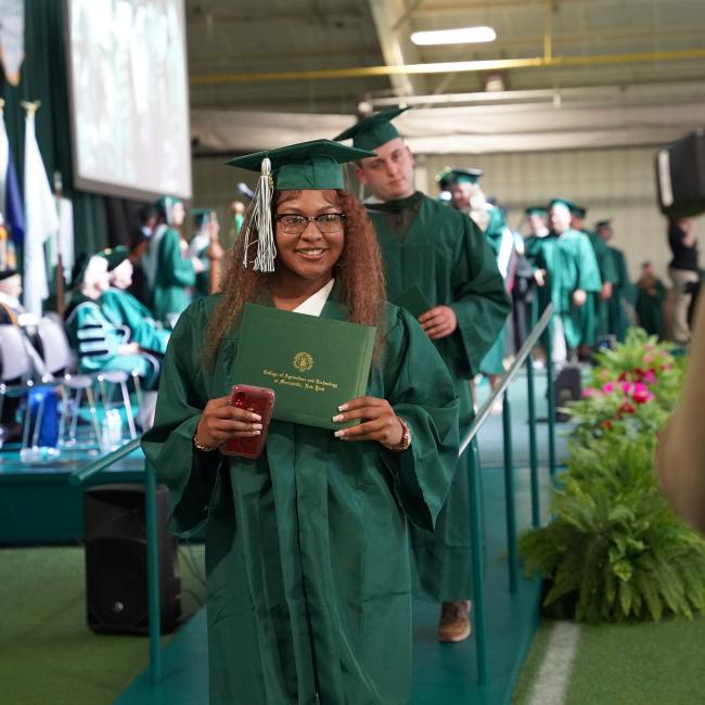 a graduate holds her diploma