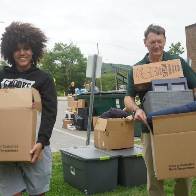 SUNY Morrisville President David Rogers assists Aniyah Smith with moving into her residence hall. 