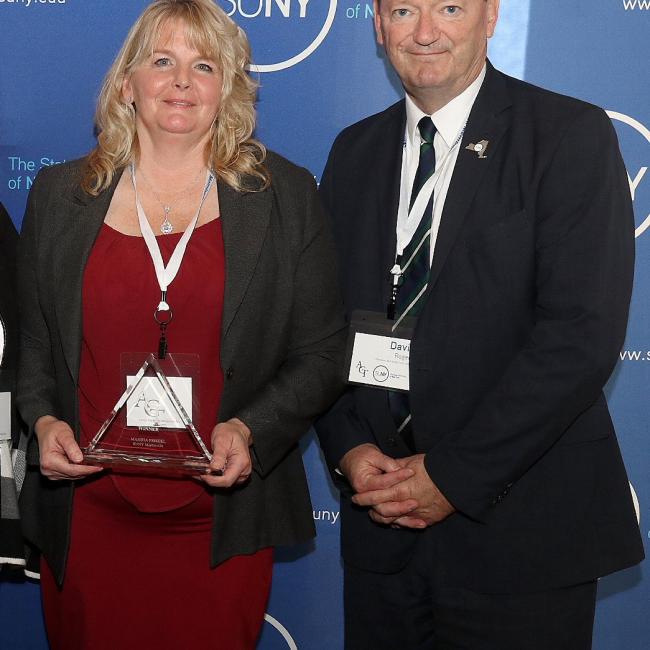 Marsha Friedel poses with President David Rogers after receiving her award.