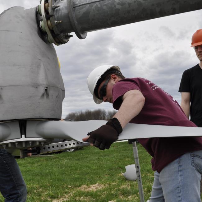 Students work on the college's wind turbine