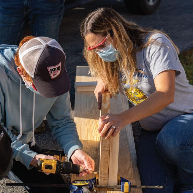 Morrisville-Eaton Central School student Kyle Pearsall, left, gets a hands-on lesson in making raised garden beds alongside ag teacher Rebecca Werbela.