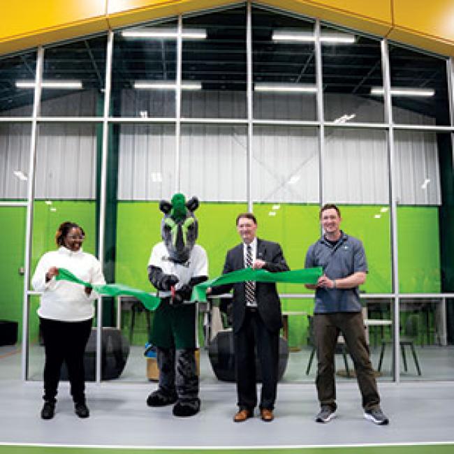 Mo the Mustang and President David Rogers cut the ribbon at the opening of the new student recreation center.