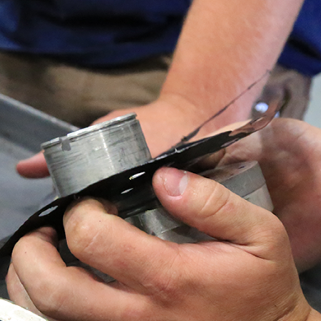 Close up of students working on engine