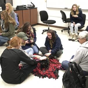 Group of students enjoying a therapy dog from PAWS of CNY