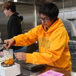 A student works in the commercial kitchen.