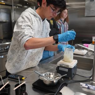 A student works in the commercial kitchen.