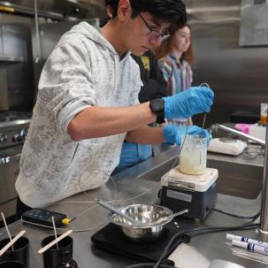 A student works in the commercial kitchen.