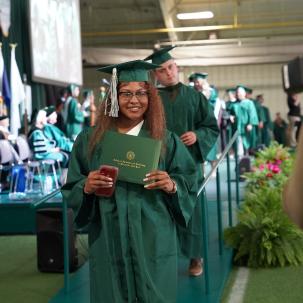 A graduate holds her diploma