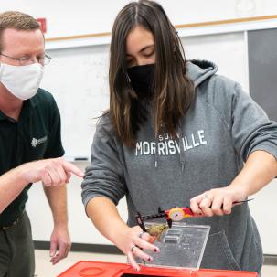 •	Associate Professor Eric Diefenbacher advises Rachel Soong, an aquaculture & aquatic science major, how to properly hold and measure a green frog. 