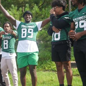 Members of the SUNY Morrisville Mustangs Football Team welcome students 