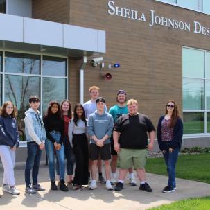 The Sheila Johnson Design Center is home to the Architectural Studies and Design program.  Students relax outside of the building before final exam week starts.