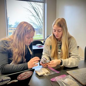 Students in Associate Professor Corey Hayes' Sheep Production and Management System class evaluate wool.